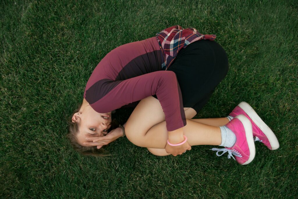 Scared young woman lying on the ground in city park